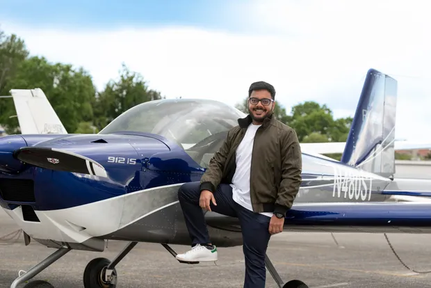 Alok Upadhyay beside a light sport aircraft on the ramp